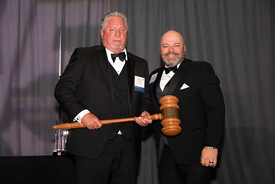 Scott Bragg and another man holding a gavel at an event.