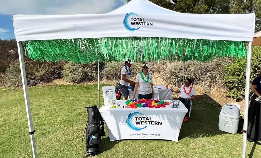 Total Western event booth set up at a golf course.