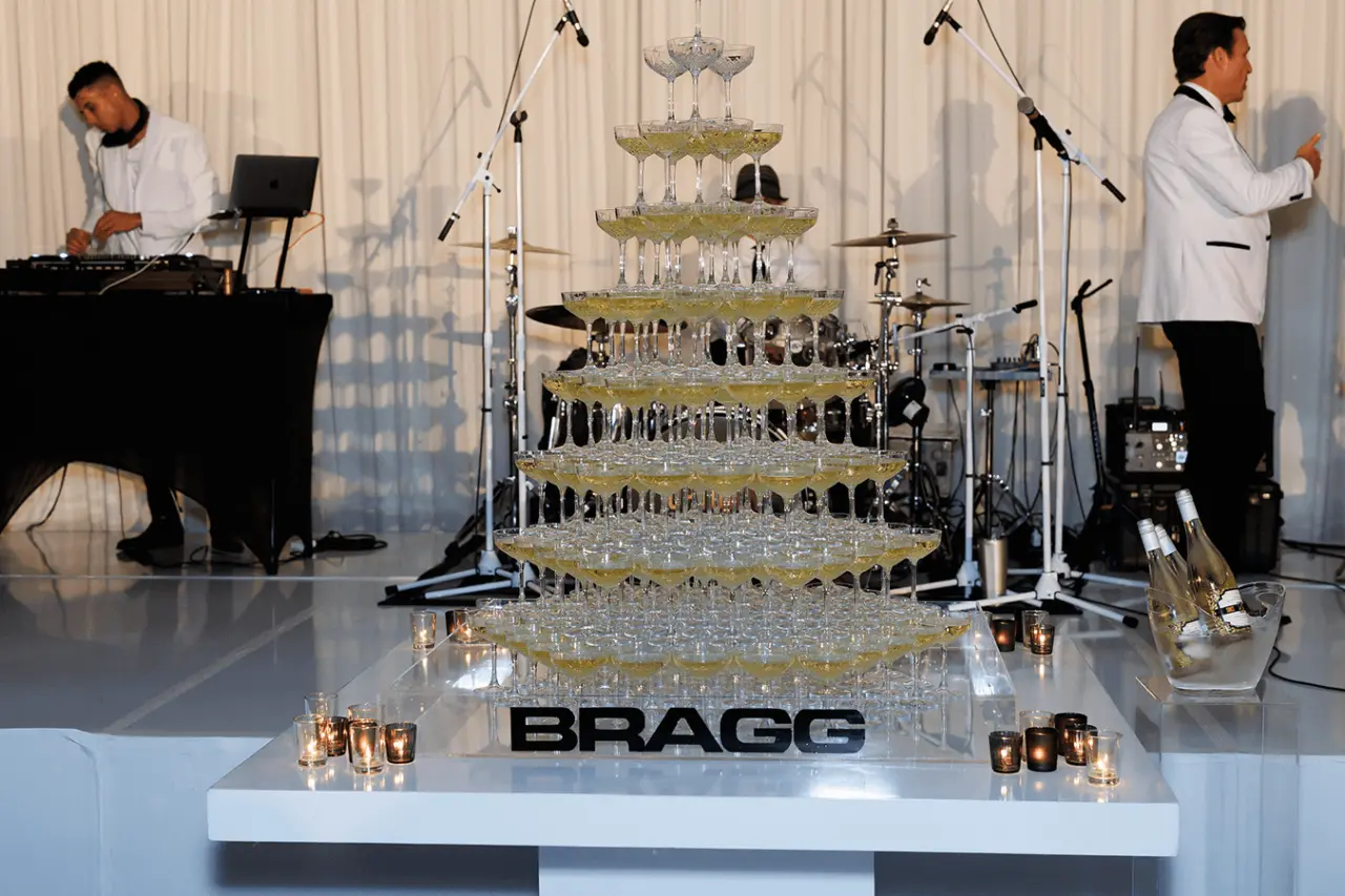 Champagne tower display with "Bragg" logo at an event.