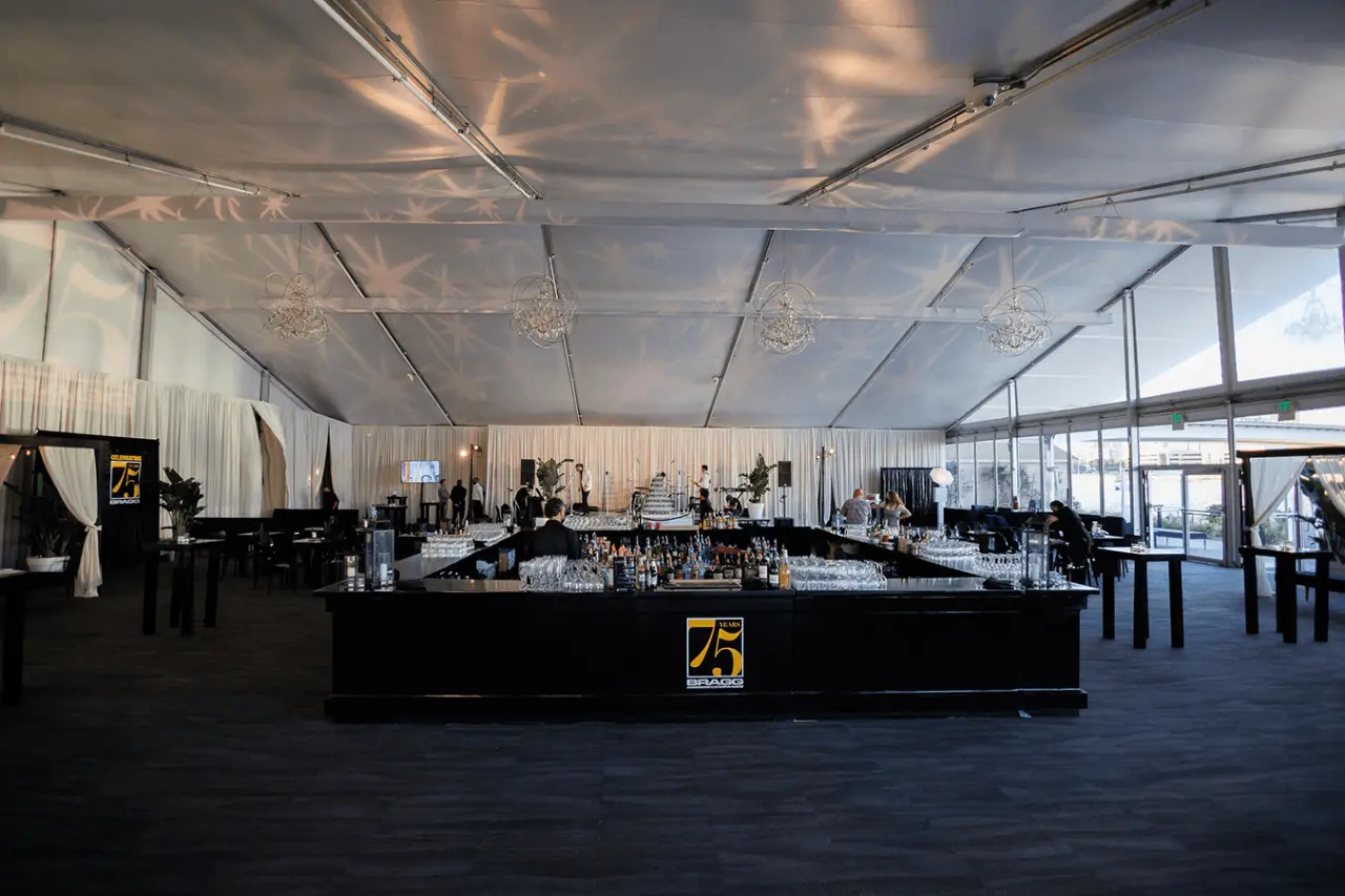 Interior view of a large event tent with a bar and seating.