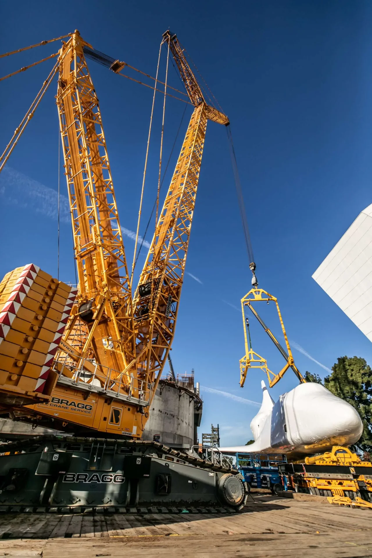 A crane is positioned over a ship, lifting a substantial cargo item, illustrating logistics.