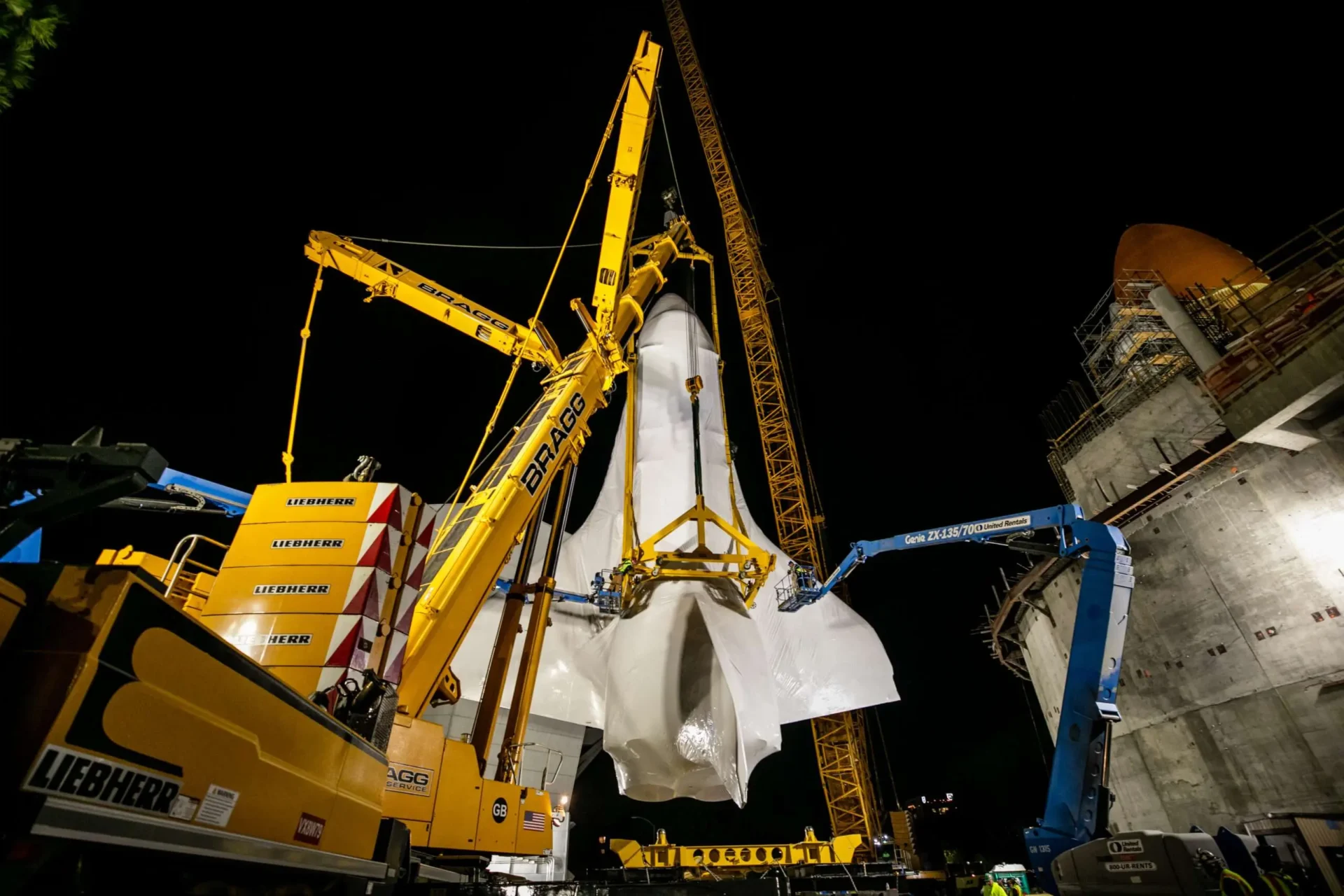 A massive crane in action, lifting a large object upward, demonstrating strength and engineering prowess.