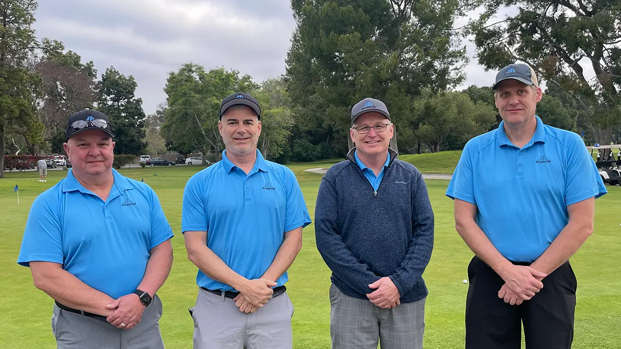 Four men in golf attire at a tournament.
