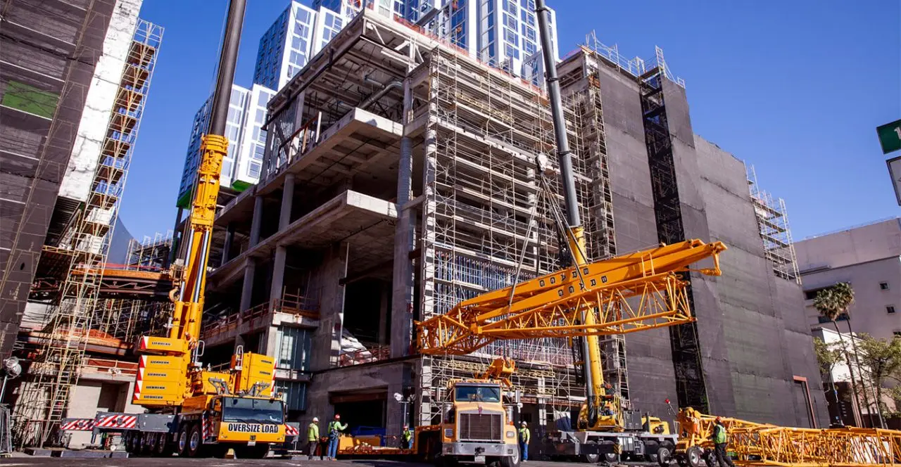 Construction site with a large crane lifting materials for a high-rise building.