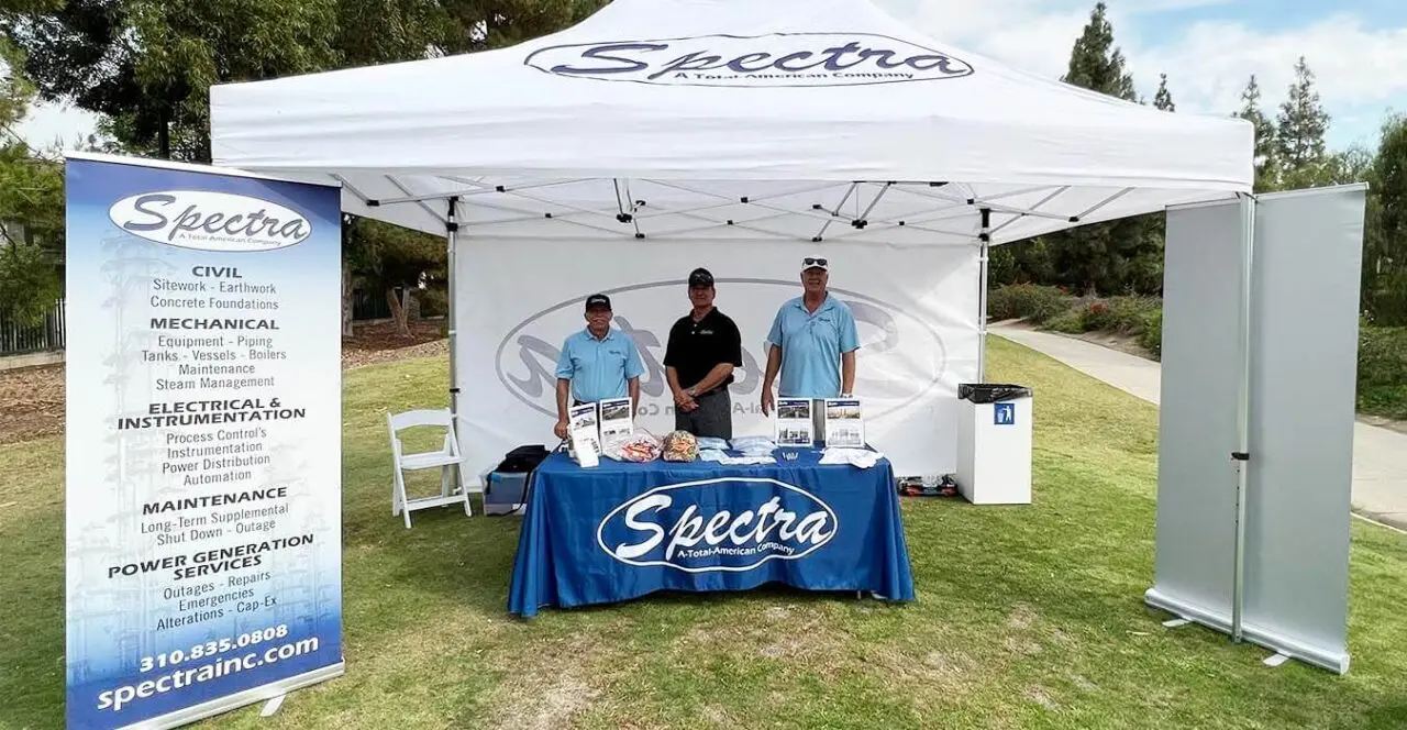 Spectra booth at a trade show, showcasing services including civil, mechanical, electrical and power generation.